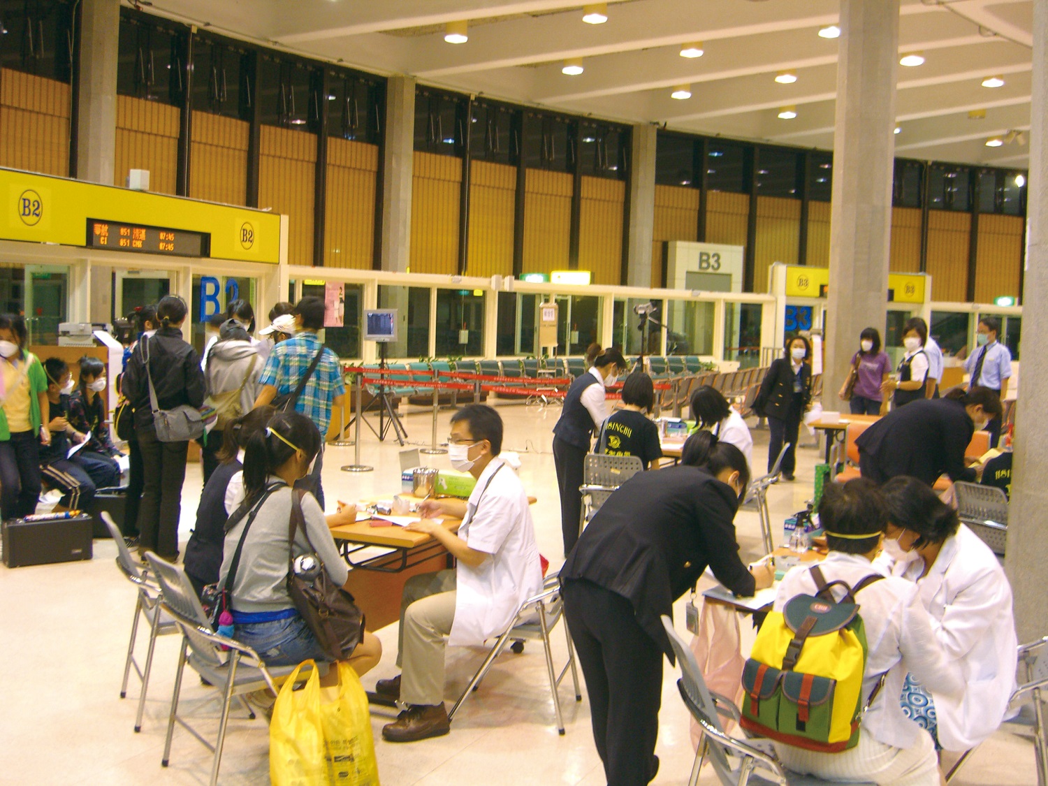 Quarantine personnel conduct fever screening and health assessments at the airport.