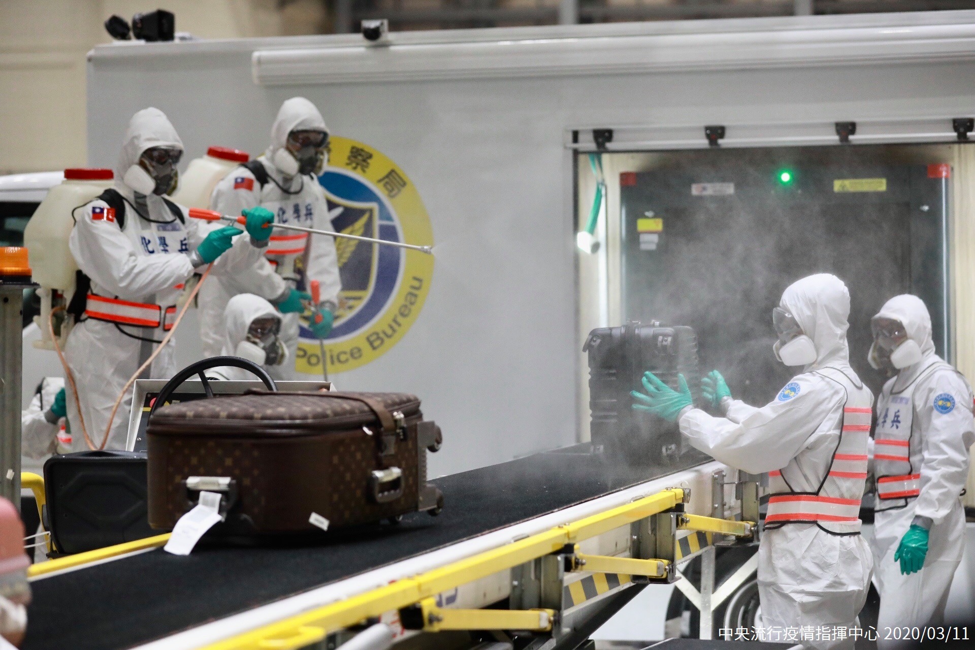 Personnel at the airport carry out disinfection of passengers' luggage.